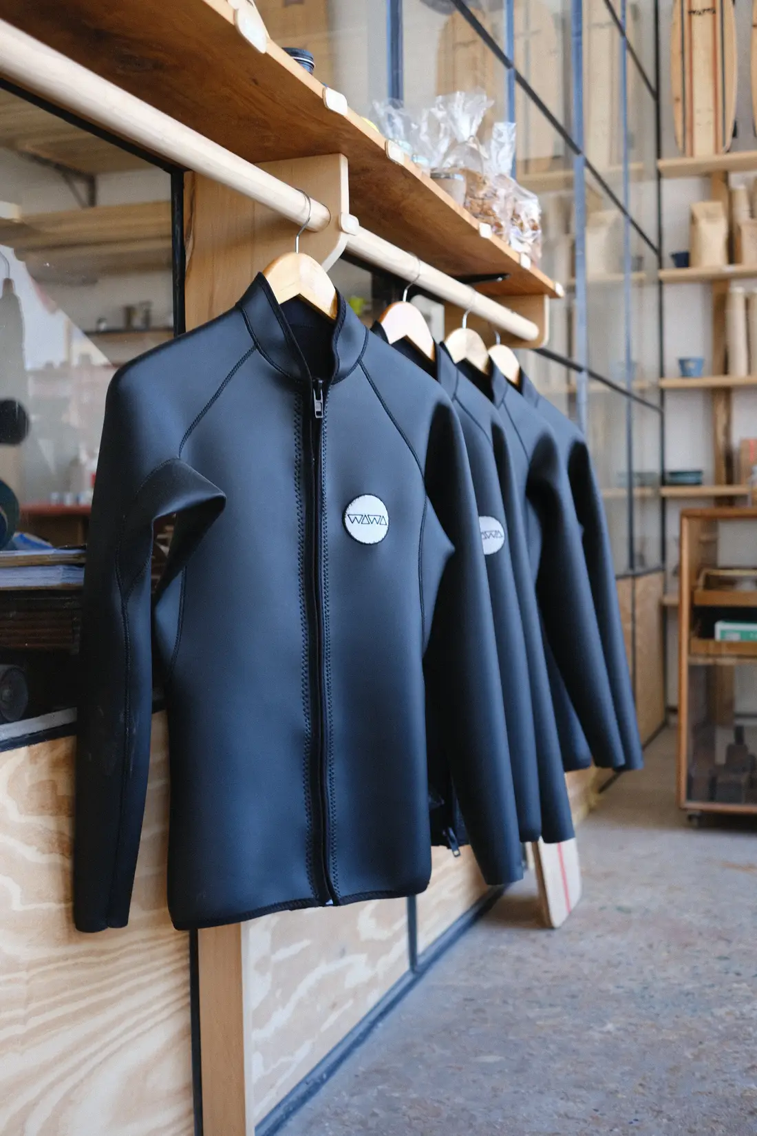Wawa Geoprene wetsuit jackets hanging on a rail in the workshop