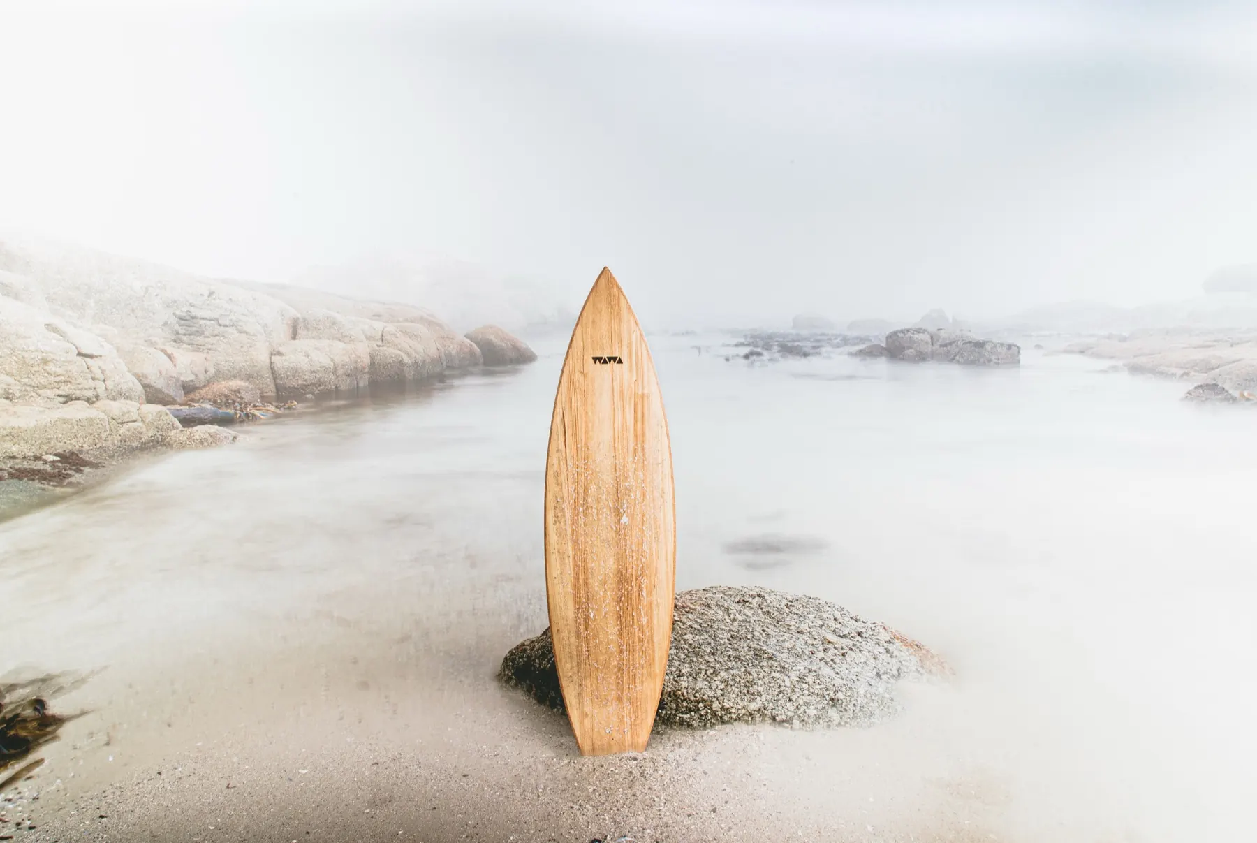 A wooden board standing upright on a rock in sea mist