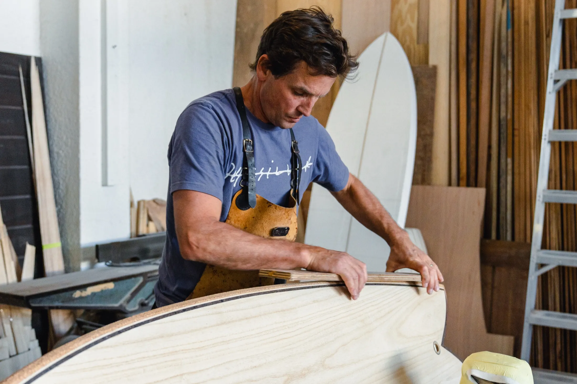 Cobus Joubert working a plane down the rail of a paulownia board